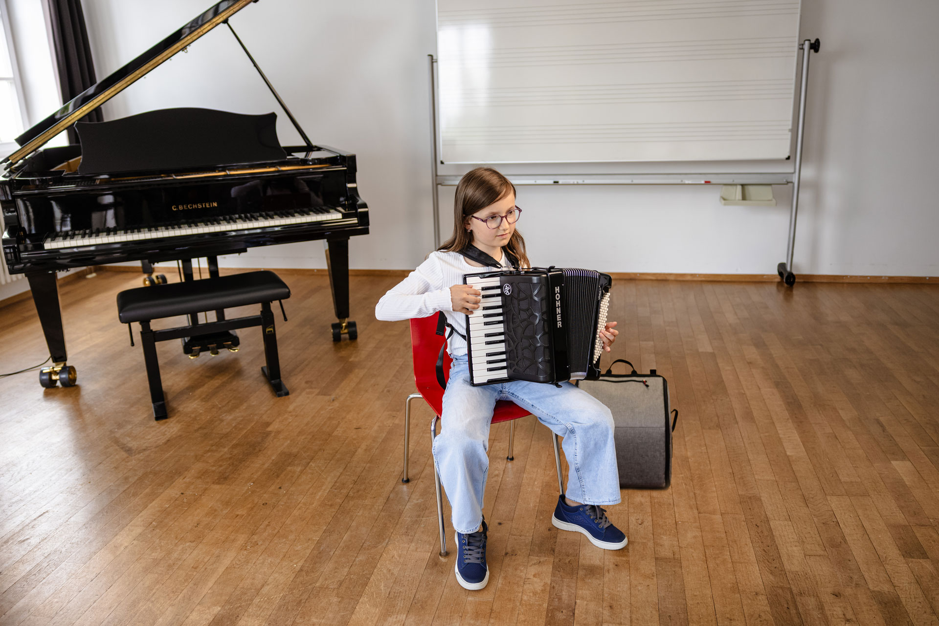 young girl, brown hair, playing HOHNER accordion